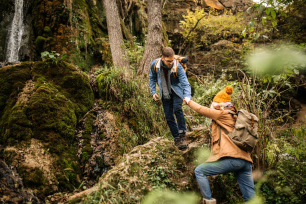 istock Hiker assisting to girlfriend to climb on the rock 1285000852