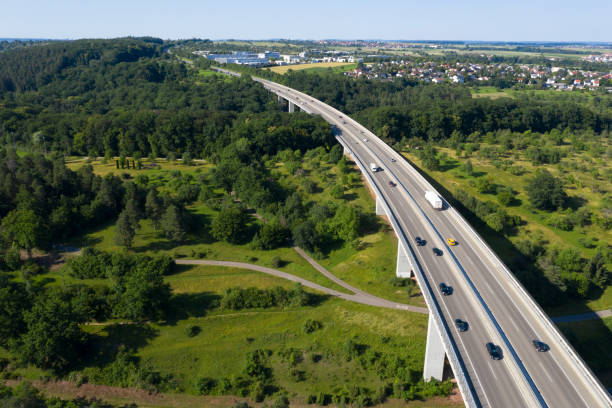 Highway bridge, aerial view Car traffic on a highway bridge over green forest, viewed from above. autobahn stock pictures, royalty-free photos & images