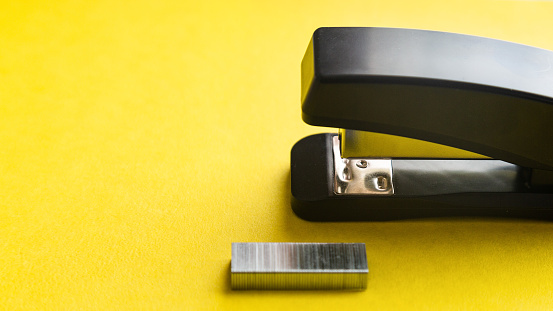 A set of office supplies Stapler and staples on yellow background.