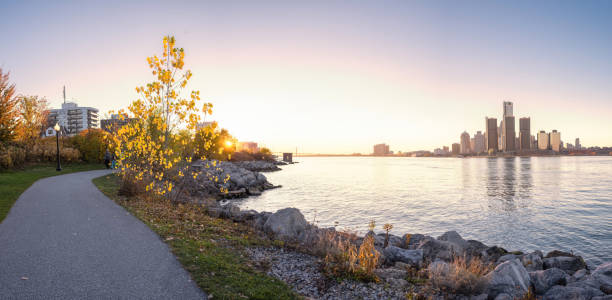 Detroit, Michigan - Autumn Skyline at Dusk The Detroit skyline as seen from across the Detroit River, in Windsor, Ontario, Canada. clear sky night sunset riverbank stock pictures, royalty-free photos & images