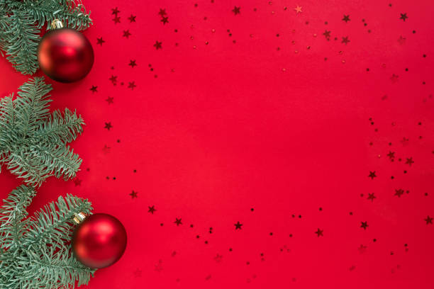 istock Christmas frame made from tree branches, glitter and baubles on red surface. Merry christmas and happy 2021 New Year concept. Flat lay, above top view, copy space 1285024773