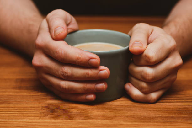 istock Man holding hot cocoa or coffee mug 1285025021
