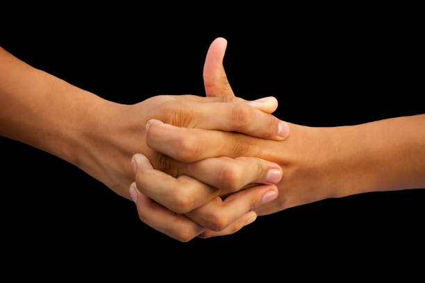 Shot of a human hand showing Linga mudra with interlocked fingers and thumb coming out of it isolated on black background. Shot of a human hand showing Linga mudra with interlocked fingers and thumb coming out of it isolated on black background. mudra stock pictures, royalty-free photos & images