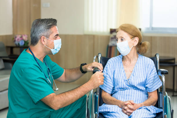 istock A nurse is guarding an elderly patient while both are wearing a surgical mask. 1285026539