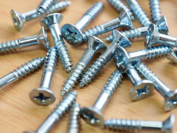 istock Wooden board background with silver screws 1285033216