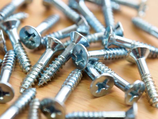 istock Wooden board background with silver screws 1285033220