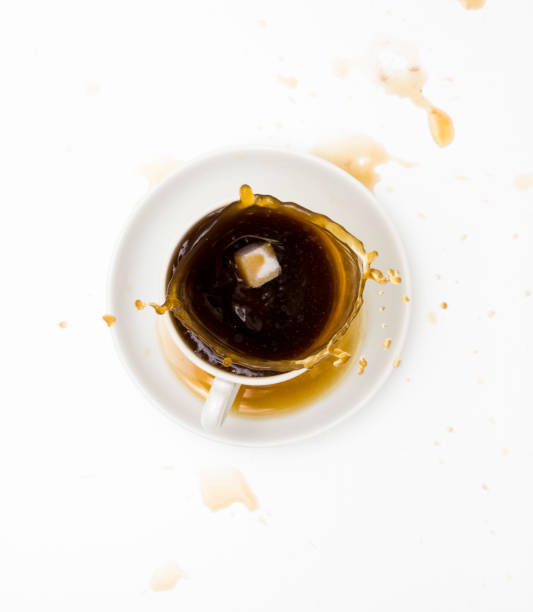 istock White Cup and saucer with tea and splash. Top view, white background. Free space for text. 1285036183