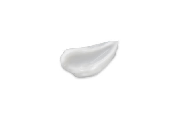 istock Color corrector strokes isolated on white background. White cream smudge smear swatch sample. Makeup foundation creamy texture. 1285036259