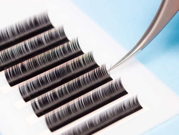 istock Tweezers remove lashes from the artificial lash tape. The work of a lashmaker. 1285036323