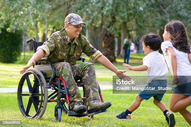 Cheerful Kids Meeting Military Dad And Running To Disabled Man Stock Photo - Download Image Now