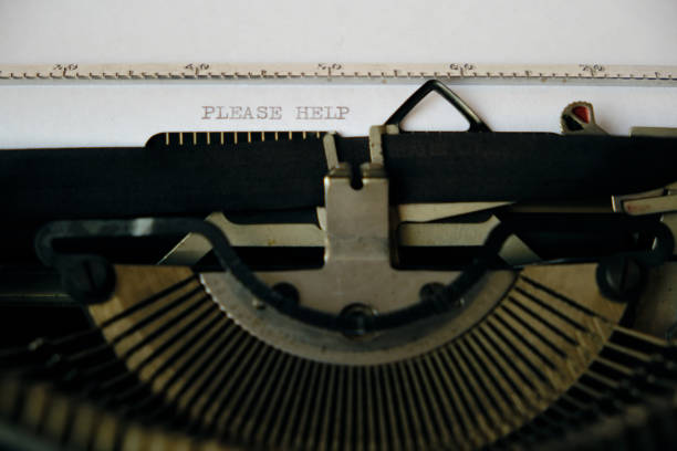 istock Inscription please help is printed on a white sheet with an old typewriter. 1285040284