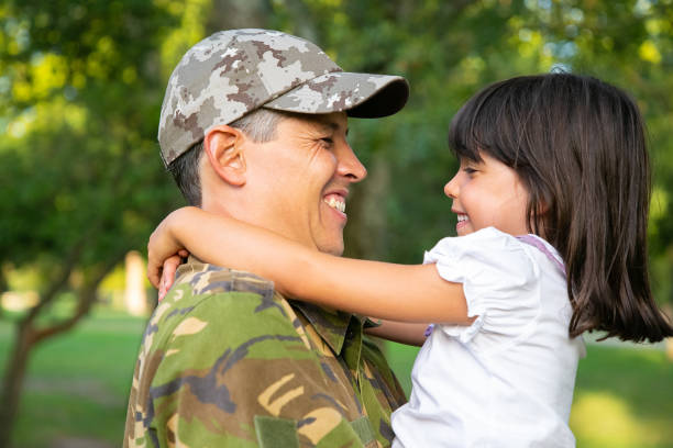istock Cheerful dad in camouflage uniform holding little daughter 1285040919
