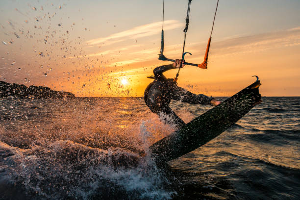 flash-foto von kitesurfer in schönen gelben sonnenuntergang am baltischen meer - people traveling flash stock-fotos und bilder