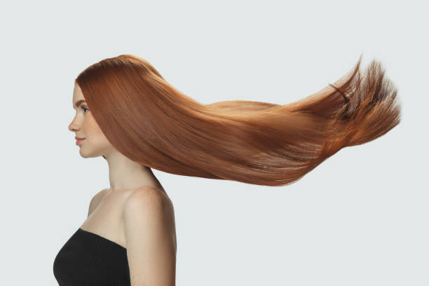 istock Beautiful model with long smooth, flying red hair isolated on white studio background. 1285048339
