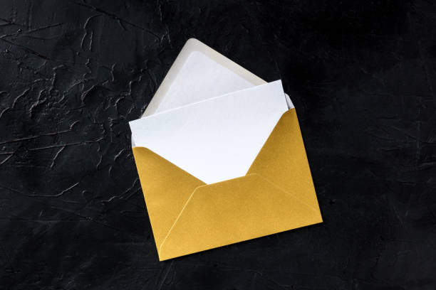 Greeting card in a golden envelope mockup, shot from above on a black background