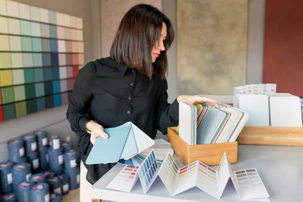 Young woman choosing materials for home renovation. interior designer looking at color samples for wall