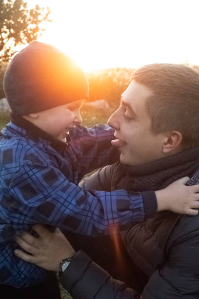 istock Dad and son hug and indulge in nature. The sun's rays pass through the faces creating a feeling of warmth and affection. Loving parents and happy childhood 1285058070