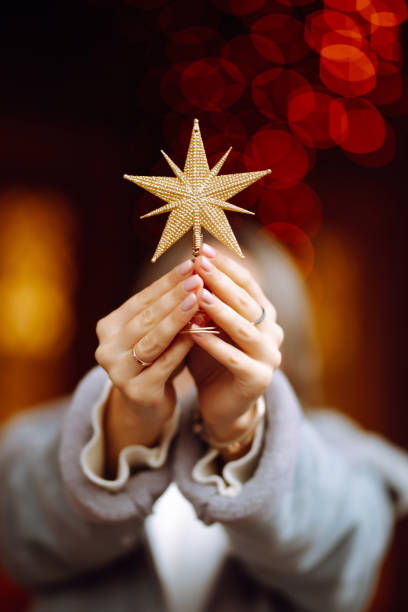 istock Golden five pointed star decoration in woman hands. 1285058336