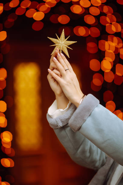 istock Golden five pointed star decoration in woman hands. 1285058350