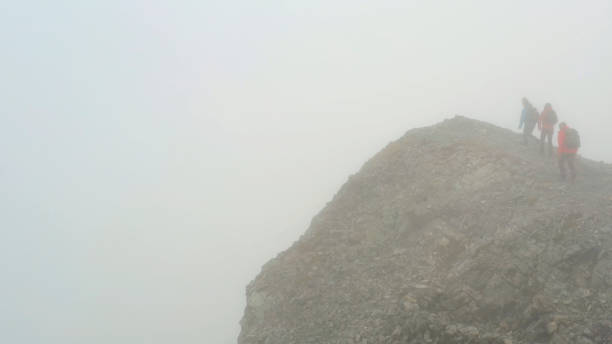 istock Three people climb a mountain on a foggy day 1285060602