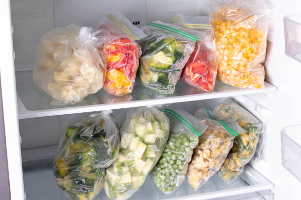 istock Plastic bags with different frozen vegetables in refrigerator 1285060894