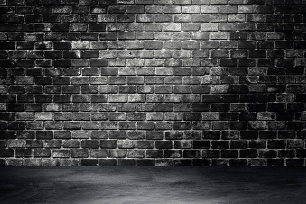 istock Studio dark room brick wall and concrete floor grunge texture background with light shading. 1285064704