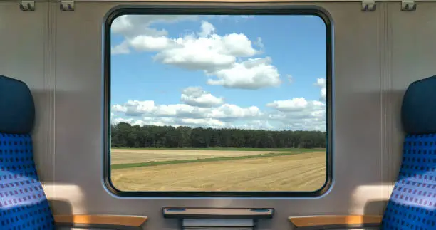 Photo of An empty blue seat in europe german train with window corn field display nature summer view on the railway road transportation during coronavirus