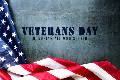 Día de los veteranos. Honrando a todos los que sirvieron. Bandera americana sobre fondo de cemento photo
