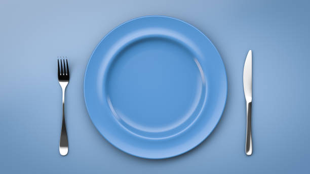 istock Set of dishes. Blue empty plate and knife with fork. Top view. 1285068493