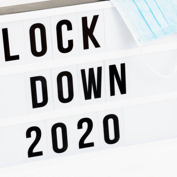 メッセージロックダウン2020と外科保護マスク付きライトボックス。2020年のワード・オブ・ザ・イヤーはロックダウンです。 - housebound ストックフォトと画像