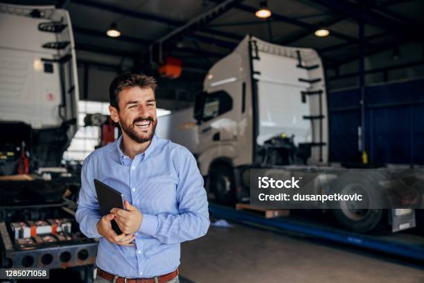 Smiling Chief Standing In Auto Park And Holding Tablet In Background Are Trucks Firm For Import And Export Stock Photo - Download Image Now