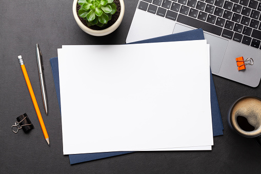 Office workplace table with blank paper page, supplies and computer. Flat lay. Top view with space for your goals