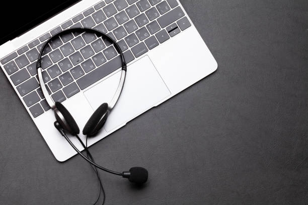 istock Office desk with headset and laptop 1285074437