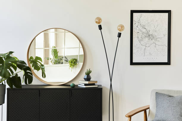 elegante composizione di interni soggiorno con design commode nero, un sacco di piante, specchio rotondo, decorazione ed eleganti accessori personali. modello. arredamento moderno della casa. - wall mirror foto e immagini stock