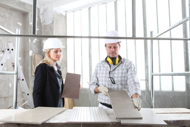 istock man and woman architect interior designer and foreman worker together with tiles samples and decorative materials discussing the project for interior decoration in the inside the construction building site 1285077115