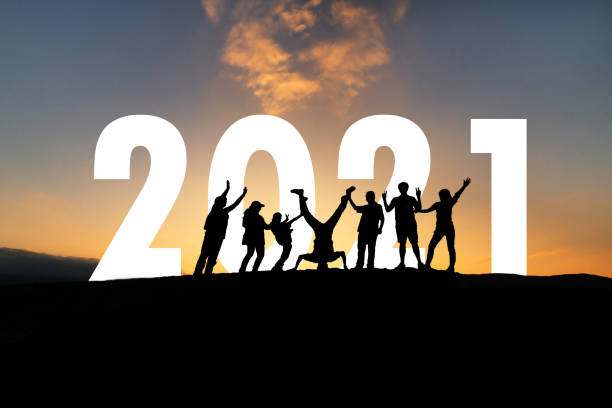 istock Silhouette Group of funny people with 2021 and sunset on background 1285079921