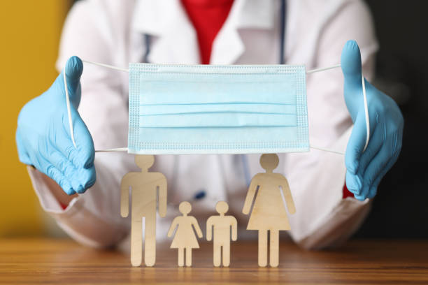 istock Doctor puting on protective medical mask on wooden men close-up 1285081592