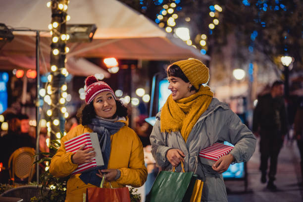 istock Two happy women are returning from Christmas shopping 1285082400