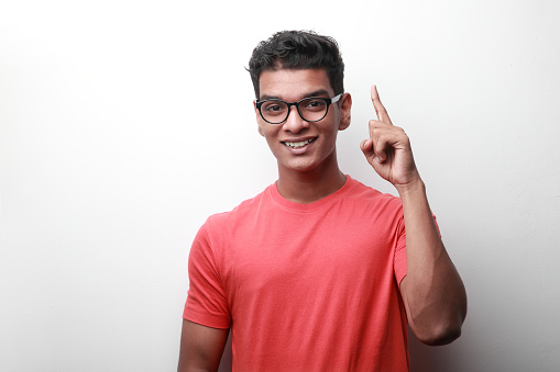 Enthusiastic young man of Indian origin shows his index finger up