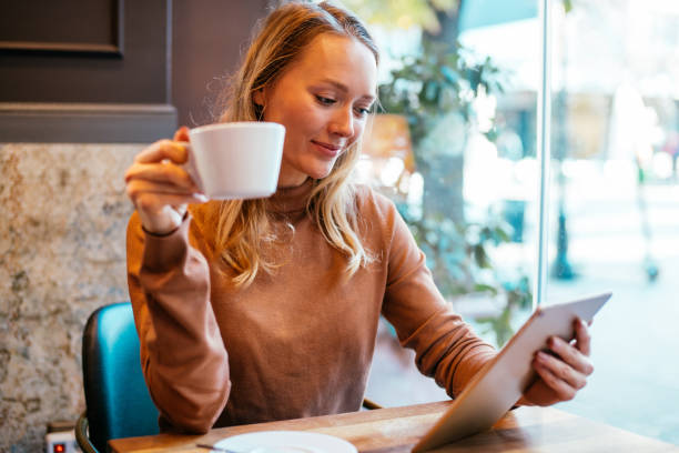 istock Woman texting on her digital tablet at cafe. 1285083533