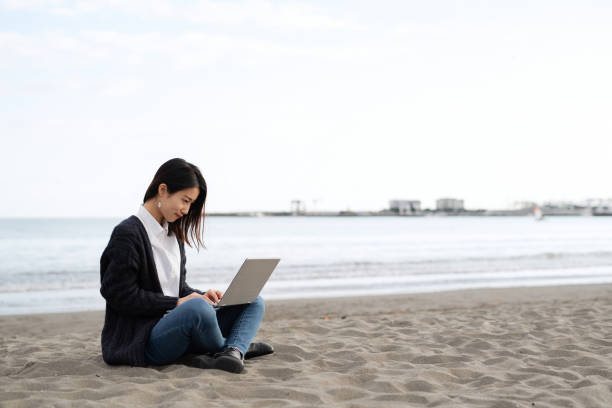 istock Young woman working from beach 1285083758