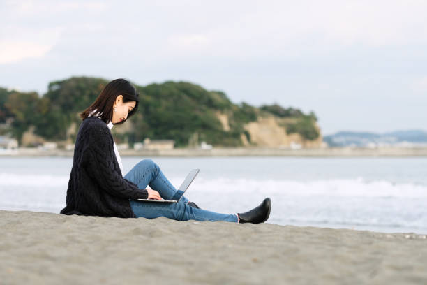 istock Young woman working from beach 1285083766