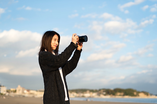 Young female tourist visiting Enoshima beach, famous tourist destination in Japan