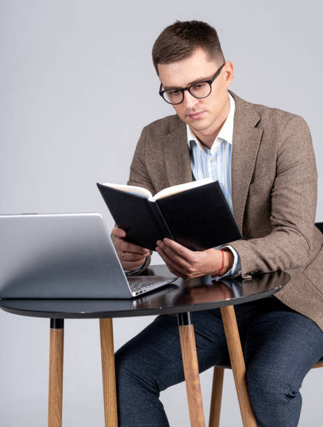 istock Male sales manager cheking schedule in notepad. Laptop on desk. Professional at work. 1285086682