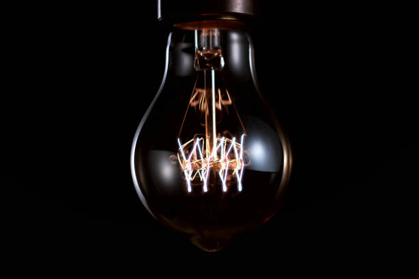 istock Luminous lamp in a cartridge on a black background close-up. 1285087092