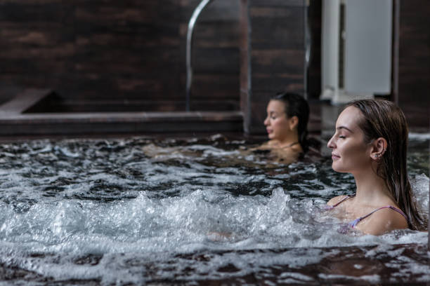 tranquilla donna in vasca gorgogliante in spa resort - treated water foto e immagini stock