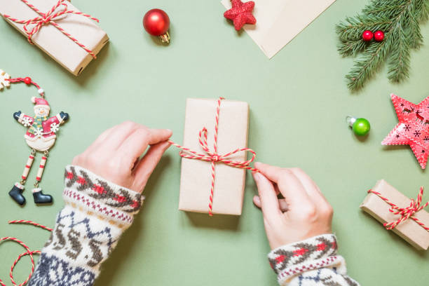 istock Women's hands tie a bow on a Christmas gift 1285088546