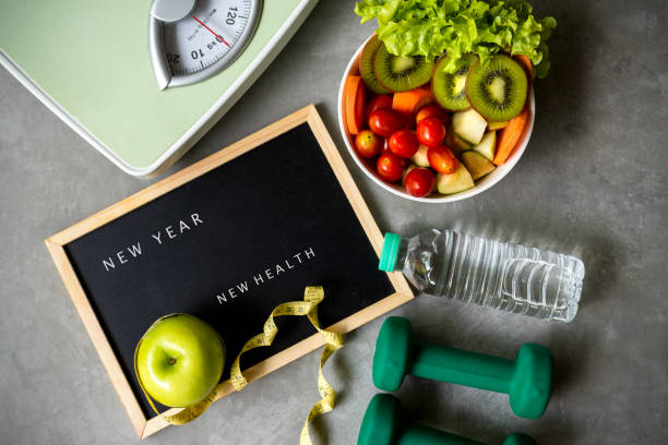 2021年新健康新年。 新鮮蔬菜沙拉和健康食品的運動設備為婦女飲食減肥背景。 - 運動訓練 圖片 個照片及圖片檔