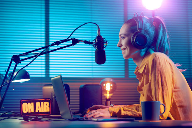 Radio broadcasting on air Young radio host working in the studio, she is smiling and broadcasting announcements broadcasting stock pictures, royalty-free photos & images