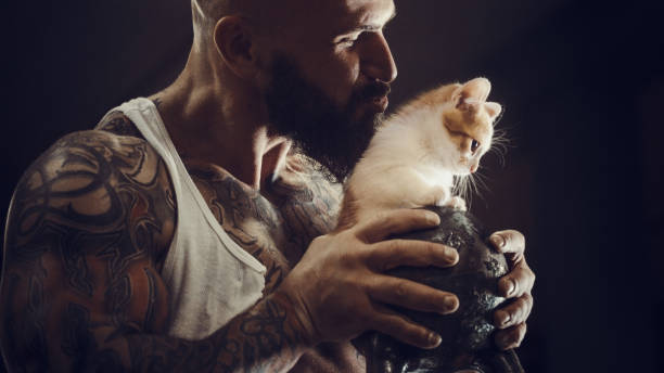 istock brutal tattooed man with cat 1285092667